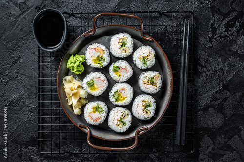 Kimbap gimbap filled with vegetables, egg, eanchovy and crab, Korean rice roll. Black background. Top view photo