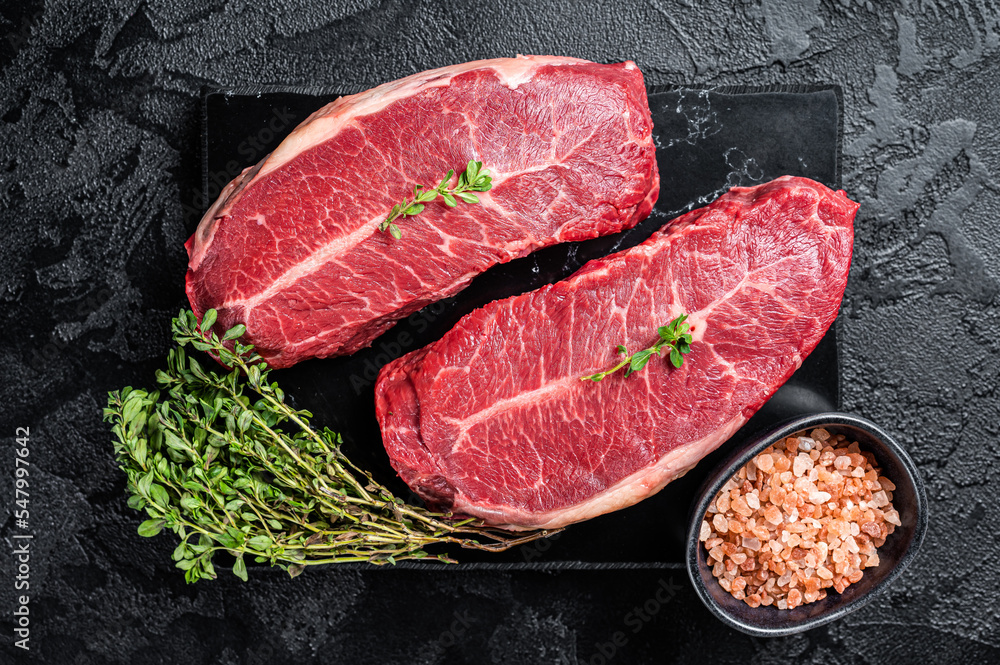 Raw wagyu oyster top blade steaks, organic beef meat. Black background. Top View