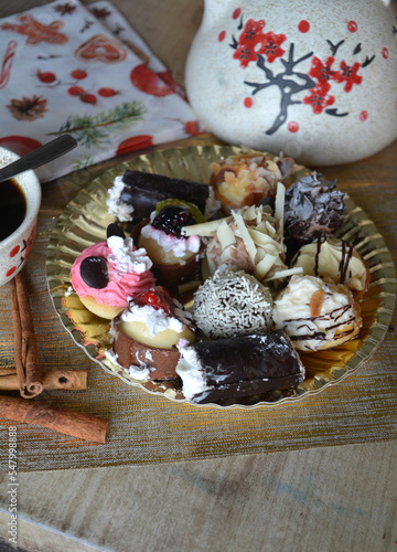 Christmas cookies on a plate and coffe cup on a decorated table. Dessert of cookies plate perfect for celebrating Christmas.
