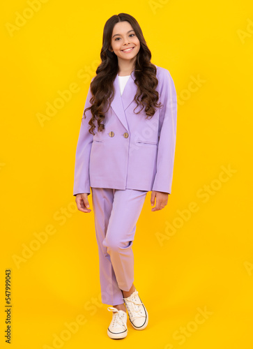 Teenager child girl casual clothes posing isolated on yellow background in studio. Kids lifestyle concept. Fashion kids suit. Happy teenager, positive and smiling emotions of teen girl.