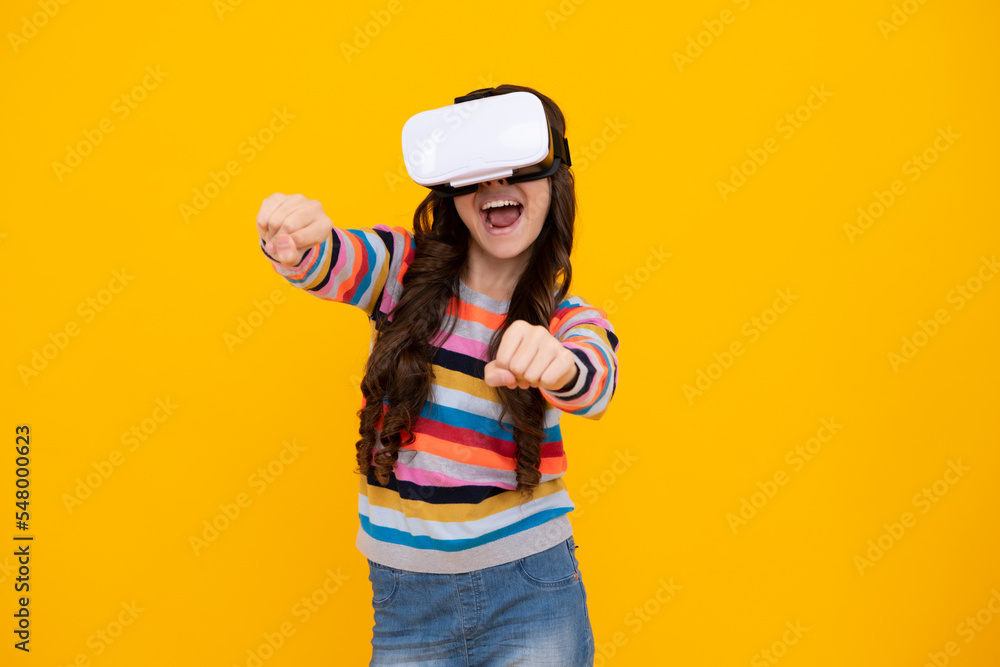 Amazed teenager. Portrait of young teen girl in VR helmet, isolated on yellow. Gamer playing VR games, VR gaming. Excited teen girl. Amazed teenager. Portrait of young teen girl in VR helmet, isolated on yellow. Gamer playing VR games, VR gaming. Excited teen girl.