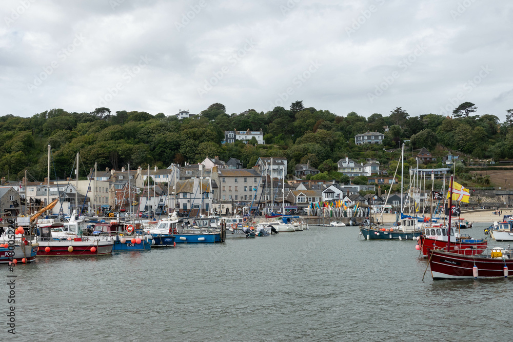 view of fishing boats in the harbour at Lyme Regis Dorset England with the town in the background