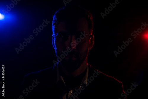 Photo of standing man and pink light on the background.