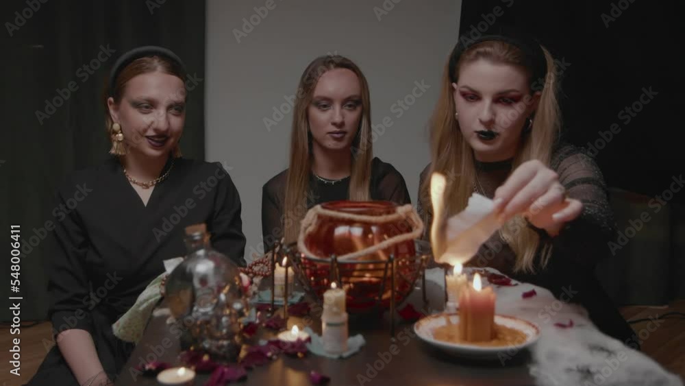 4K. Three female witches in a dark room conduct mystical sessions 4K. Three female witches in a dark room conduct mystical sessions