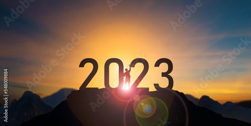 Silhouette businessman celebrating raising arms between word 2023 with sunset sky at Mountain and number like 2023 abstract background.concept of start with strategy,win,plan,goal and objective target photo