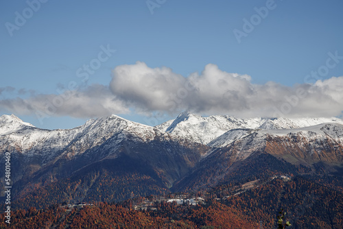 Mountains with snow-capped peaks. Beautiful panorama. Clouds over the mountains.