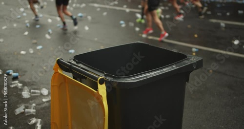 Close u of top of trash bin for rubbish at refreshment area on sport event. Athletes running on street around. Marathon run race, Berlin, Germany photo