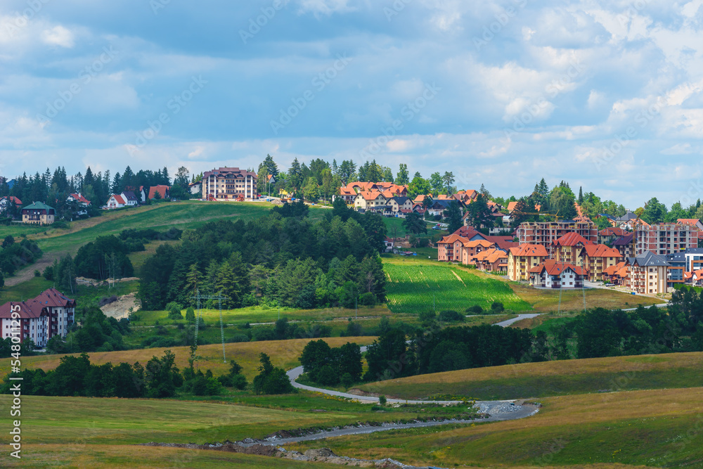 Beautiful picturesque Zlatibor region landscape with distinctive architectural style houses scattered over green hills