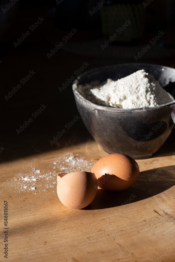 Ingredients for making dough - flour in a bowl, eggs. Hard light Ingredients for making dough - flour in a bowl, eggs. Hard light