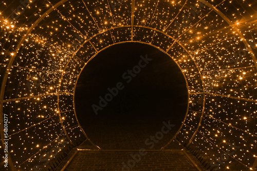 tunnel and illuminations of orange yellow white on a black dark background. New Year's Eve Christmas. Photoona festive atmosphere photo