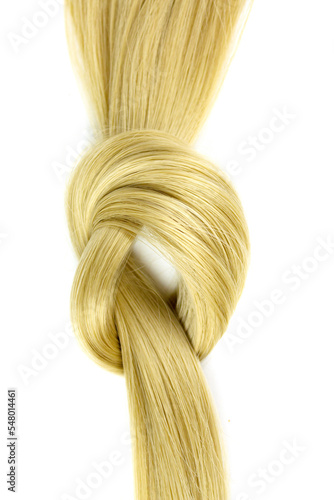 Hairdresser service, hair strength, haircut, hairstyle. Strand of honey blonde hair lock tied in knot on white background, top view.