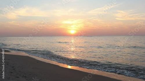 Beautiful beach in Palmahim, Israel at sunset over the water with wave crashing sound in the background photo