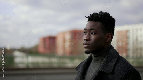 Pensive elegant black African man walking outside in city thinking about life