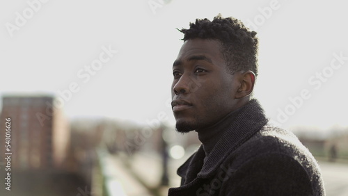 Pensive black man thinking about life on top of city bridge. Elegant African person close-up contemplative face