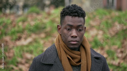 Pensive black man standing outside in cold winter season wearing scar and coat2