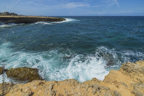 Gorgeous view of big turquoise waves Atlantic ocean on western rocky coast of island of Aruba.