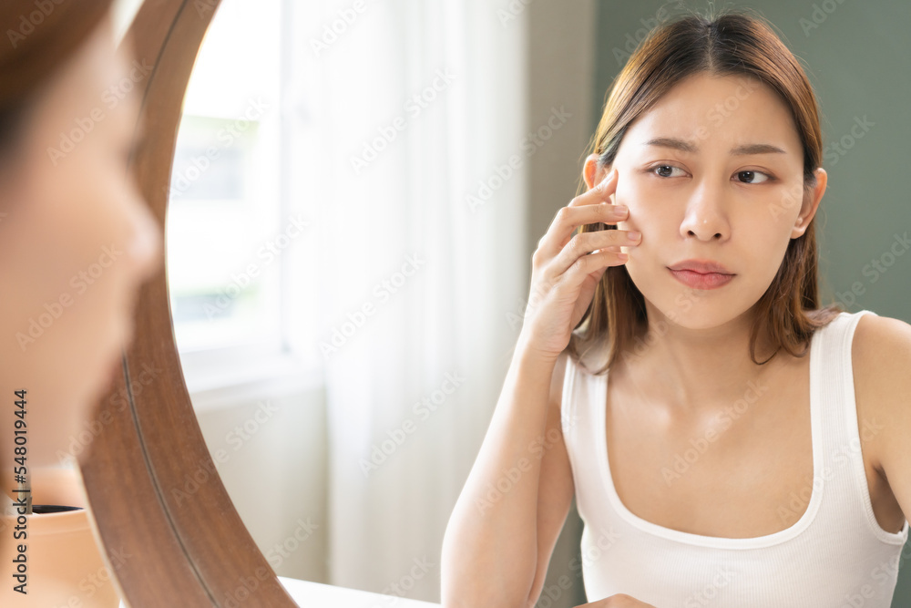 Dermatology, puberty asian young woman, girl face worry looking mirror, allergic reaction from cosmetic, red or dark spot, rash. Beauty care from skin problem treatment, blemish wrinkle from sunlight. Dermatology, puberty asian young woman, girl face worry looking mirror, allergic reaction from cosmetic, red or dark spot, rash. Beauty care from skin problem treatment, blemish wrinkle from sunlight.