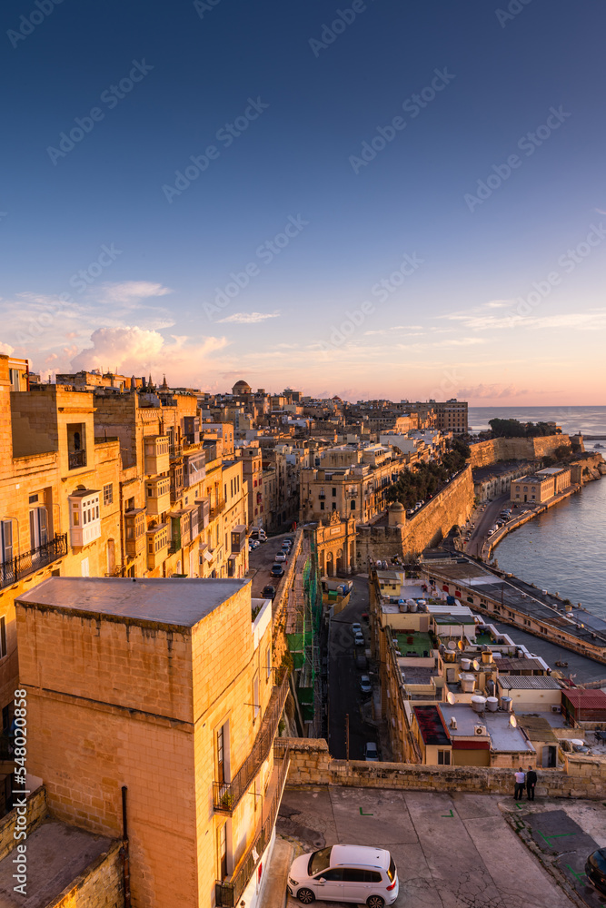 Fototapeta premium Sunrise at the Grand Harbour of Malta with the ancient walls of Valletta