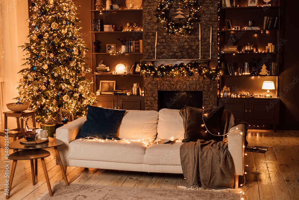 Fototapeta premium Christmas interior in the living room. White sofa and the Christmas tree
