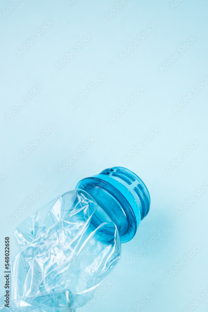 Close up of plastic stripped bottle on blue background Close up of plastic stripped bottle on blue background