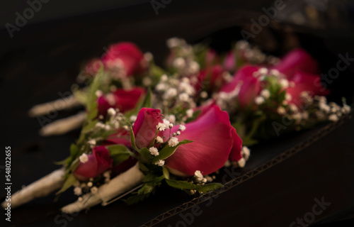boutonnières para la solapa de los acompañantes del novio , rosa roja con flor de nube photo