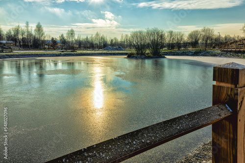 Fototapeta Naklejka Na Ścianę i Meble -  In the park, the pond water is frozen into ice