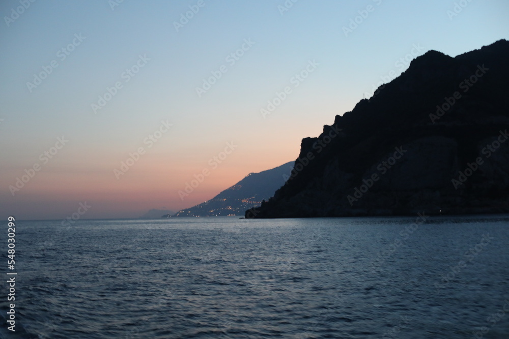 Sunset view of the sea and mountain. Scenic view of the coast of island of the region. Evening landscape with mountains and sea. Dusk time lapse. Seascape with blue sky and clouds. Sea and rocks Sunset view of the sea and mountain. Scenic view of the coast of island of the region. Evening landscape with mountains and sea. Dusk time lapse. Seascape with blue sky and clouds. Sea and rocks