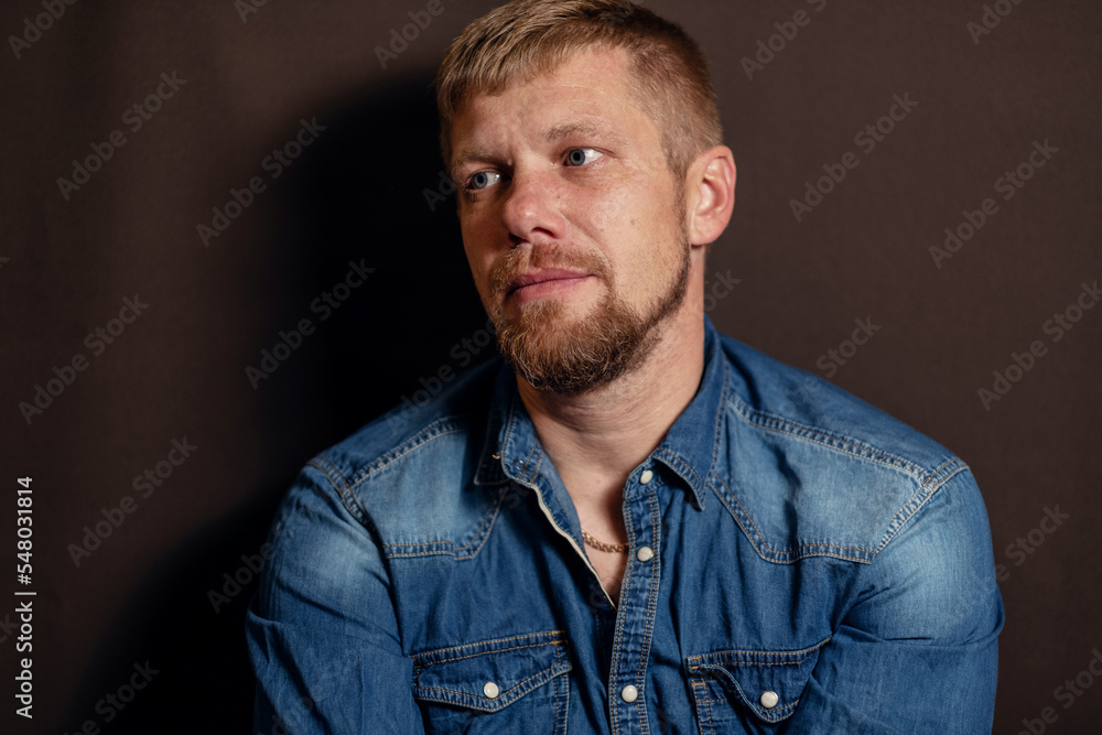 Fototapeta premium close-up portrait of a man. a man with a beard. man in blue denim shirt