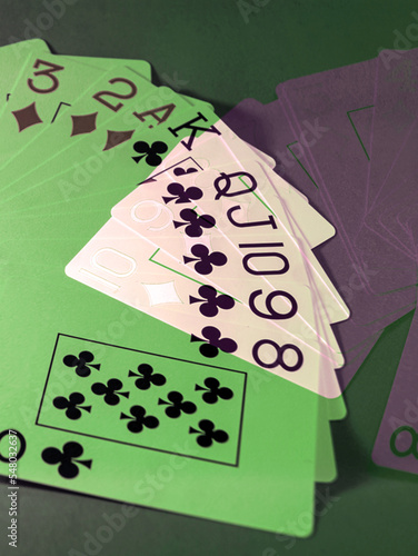 Abstraction - A fan of playing cards of diamonds and cross suits, on a green background.