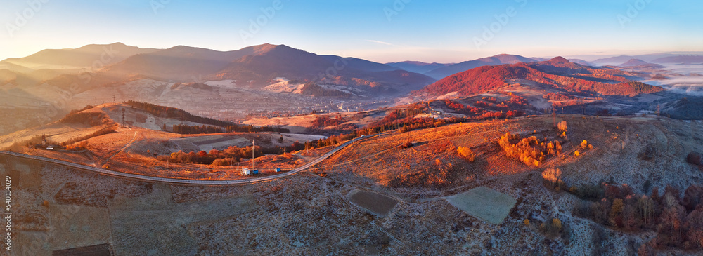 November mountain panorama. Mountain autumn misty Sunrise landscape. Morning valley covered by fog aerial scene. Seasonal fall scenery of Carpathian range. Travel destination