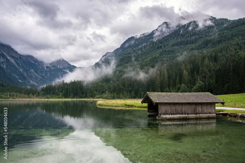 Lake Jagersee in Austria near the town of Wagrain. Water and an old wooden house by the shore.
