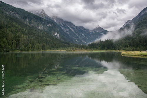 Lake Jagersee in Austria near the town of Wagrain. Water and high mountains in the clouds.