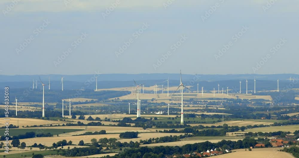 Wind farm and wind mills near Marienmünster and Fürstenau seen from Köterberg. Large wind farms in rural areas are a hot topic in Germany. Wind farm and wind mills near Marienmünster and Fürstenau seen from Köterberg. Large wind farms in rural areas are a hot topic in Germany.