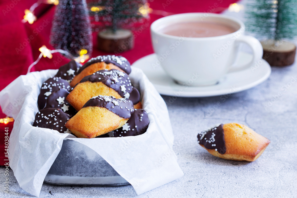 Traditional French madeleine cookies served with coffee, Christmas decor.