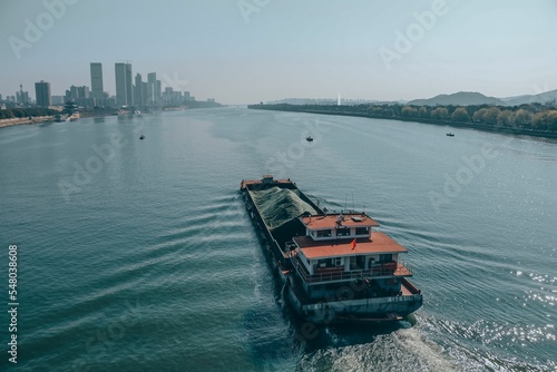 Long boat in a river with a background of a city skyline photo