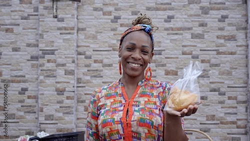 Video en primer plano de una hermosa mujer latina afro caribeña muy sonriente viendo a cámara y vendiendo sus alimentos  caribeños photo