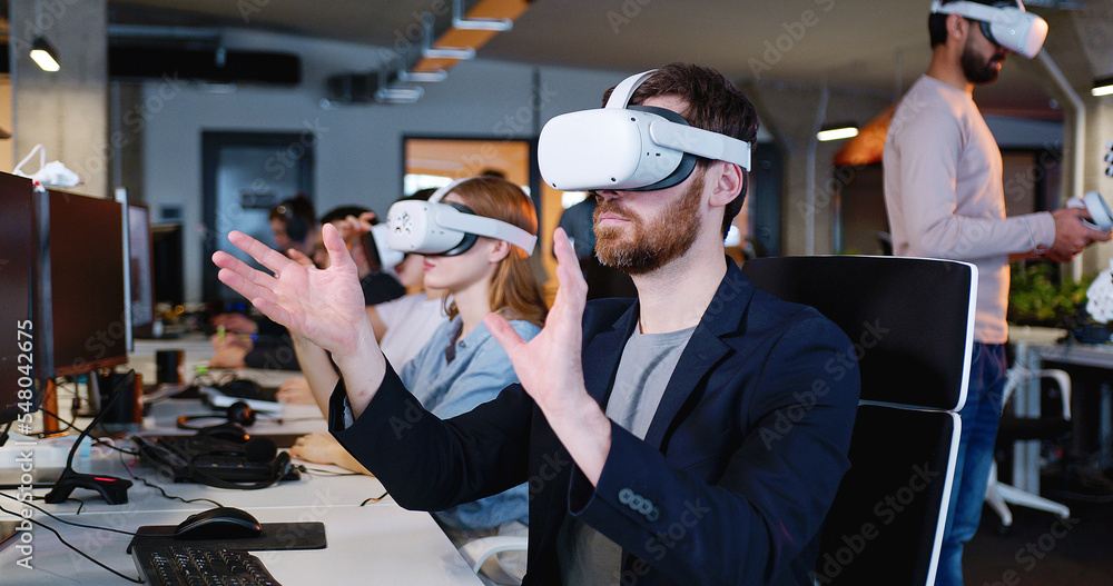 Male in headset having virtual reality experience. Moving hands in air. Futuristic. Augmented. Robot on the background. Android. Humanoid