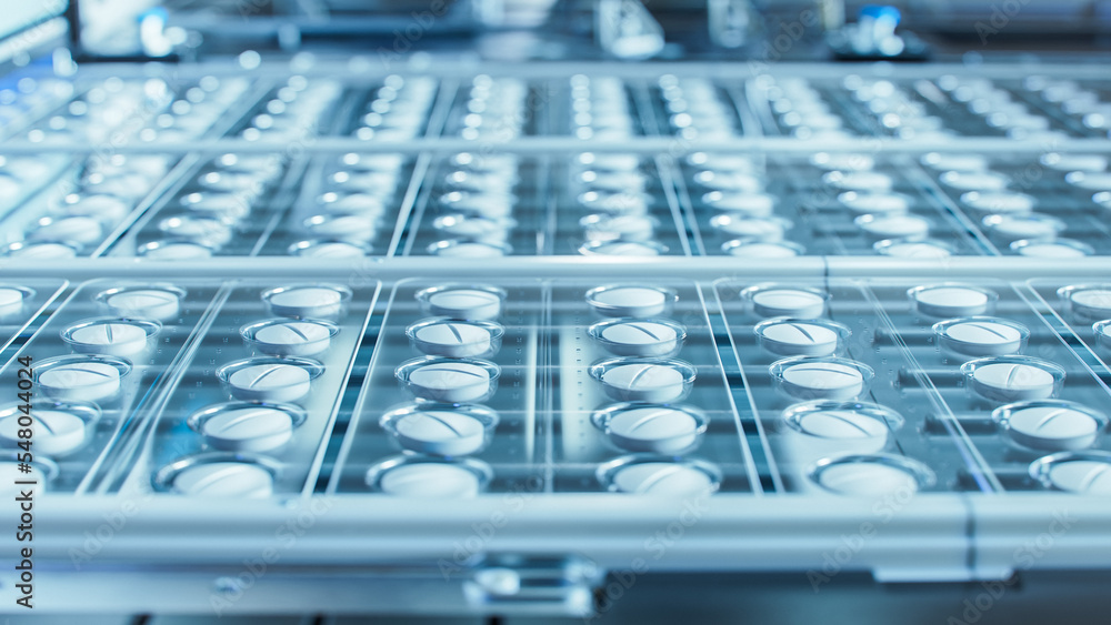Macro Shot of White Pills During Production and Packing Process on Modern Pharmaceutical Factory. Medical Drug Manufacturing. Macro Shot of White Pills During Production and Packing Process on Modern Pharmaceutical Factory. Medical Drug Manufacturing.