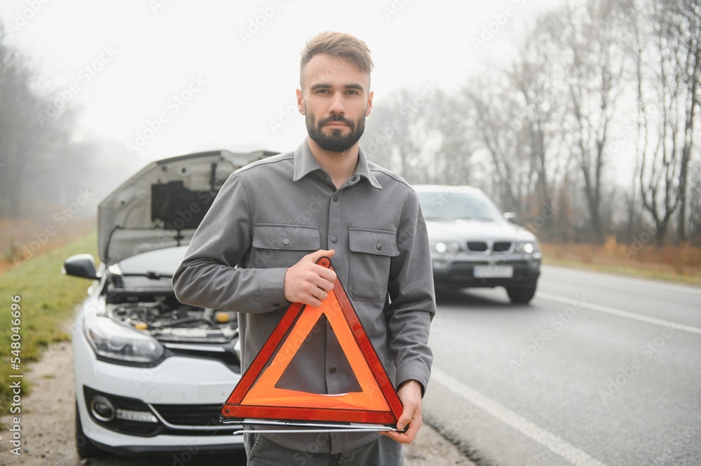 Sad man near broken car searching help in field Sad man near broken car searching help in field