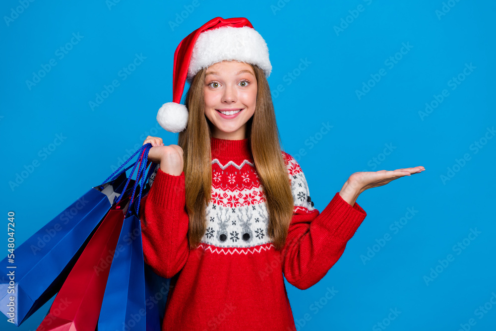 Obraz premium Photo of cute girl with straight hairstyle dressed red pullover palm present offer hold new clothes isolated on blue color background