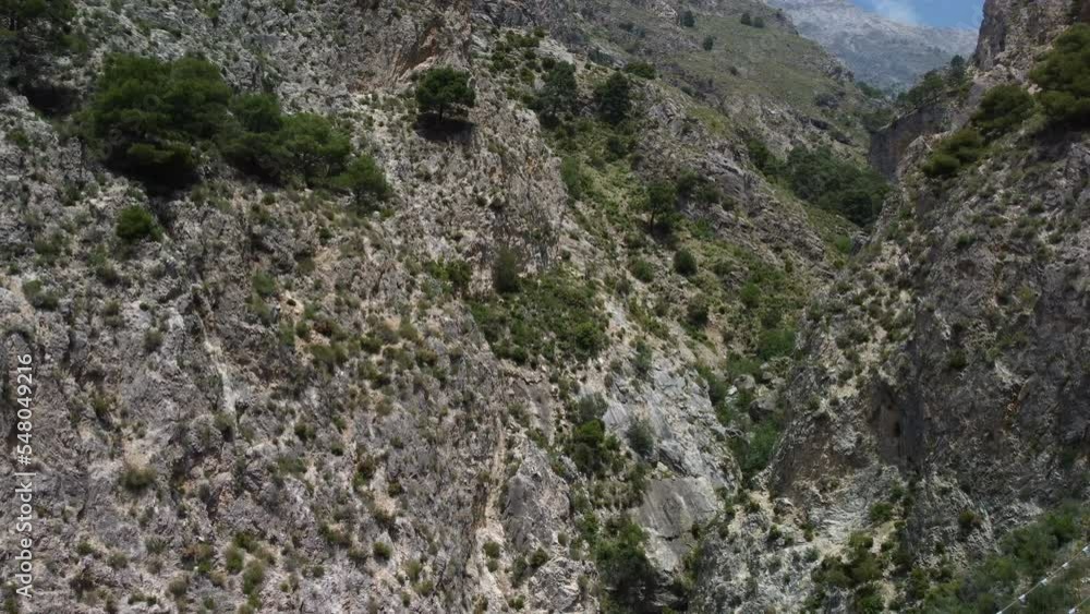 Aerial view of suspension bridge of 'El Saltillo Canillas de Aceituno' in the beautiful mountain landscape of Canillas de Aceituno on a sunny day, Malaga, Spain Aerial view of suspension bridge of 'El Saltillo Canillas de Aceituno' in the beautiful mountain landscape of Canillas de Aceituno on a sunny day, Malaga, Spain