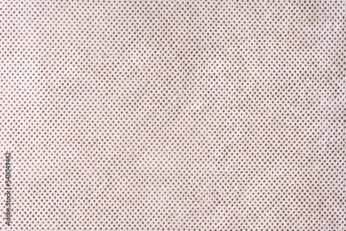 Texture background of velours beige fabric with dots pattern. Fabric texture of upholstery furniture textile material, design interior, wall decor. Fabric texture close up, backdrop, wallpaper.