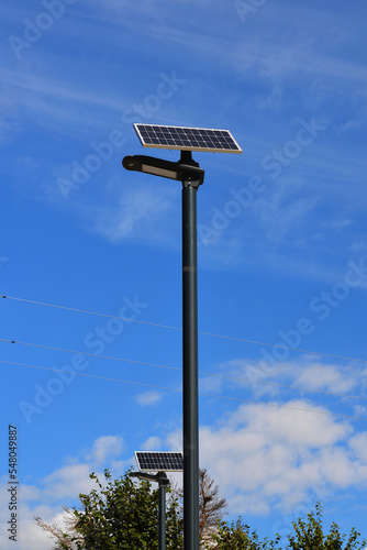 street lamp with modern solar panel lighting technology against the blue sky