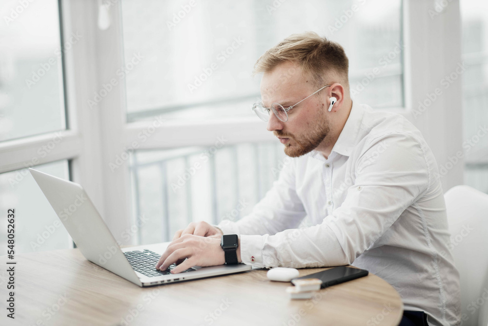 concentrated man works on the internet using a laptop, european man.