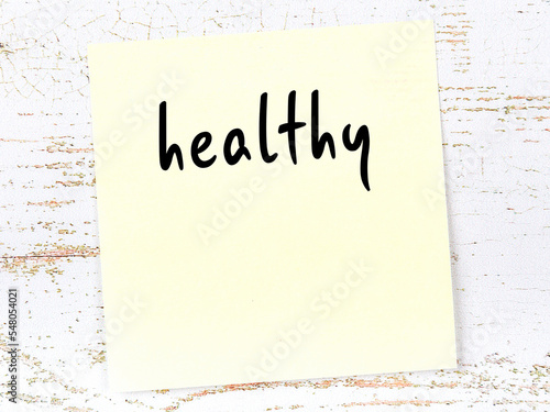 Фотография Yellow sheet of paper with word healthy. Reminder concept