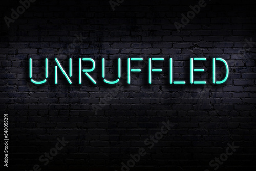 Night view of neon sign on brick wall with inscription unruffled photo