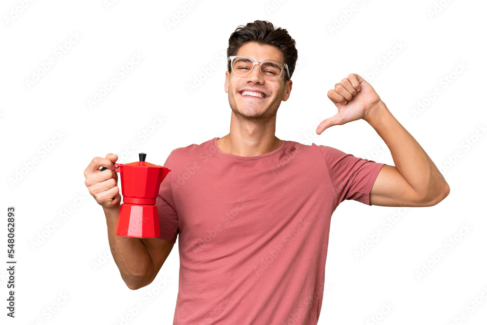 Young caucasian man holding coffee pot over isolated background proud and self-satisfied Young caucasian man holding coffee pot over isolated background proud and self-satisfied