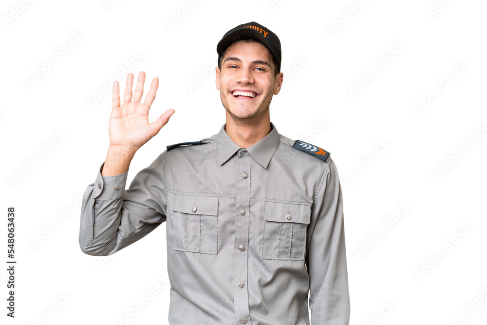 Young security man over isolated background saluting with hand with happy expression Young security man over isolated background saluting with hand with happy expression