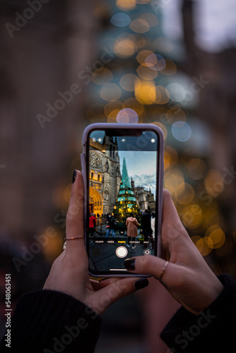 Woman taking a picture of the big glass and steel tree in Bordeaux with her phone,