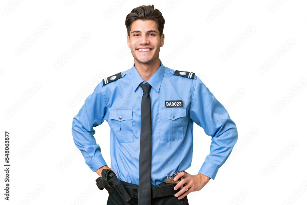 Young police man over isolated background posing with arms at hip and smiling